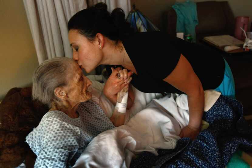 Nurse Rachel Haenel kisses terminally ill patient Jackie Beattie, 83, at the Hospice of...