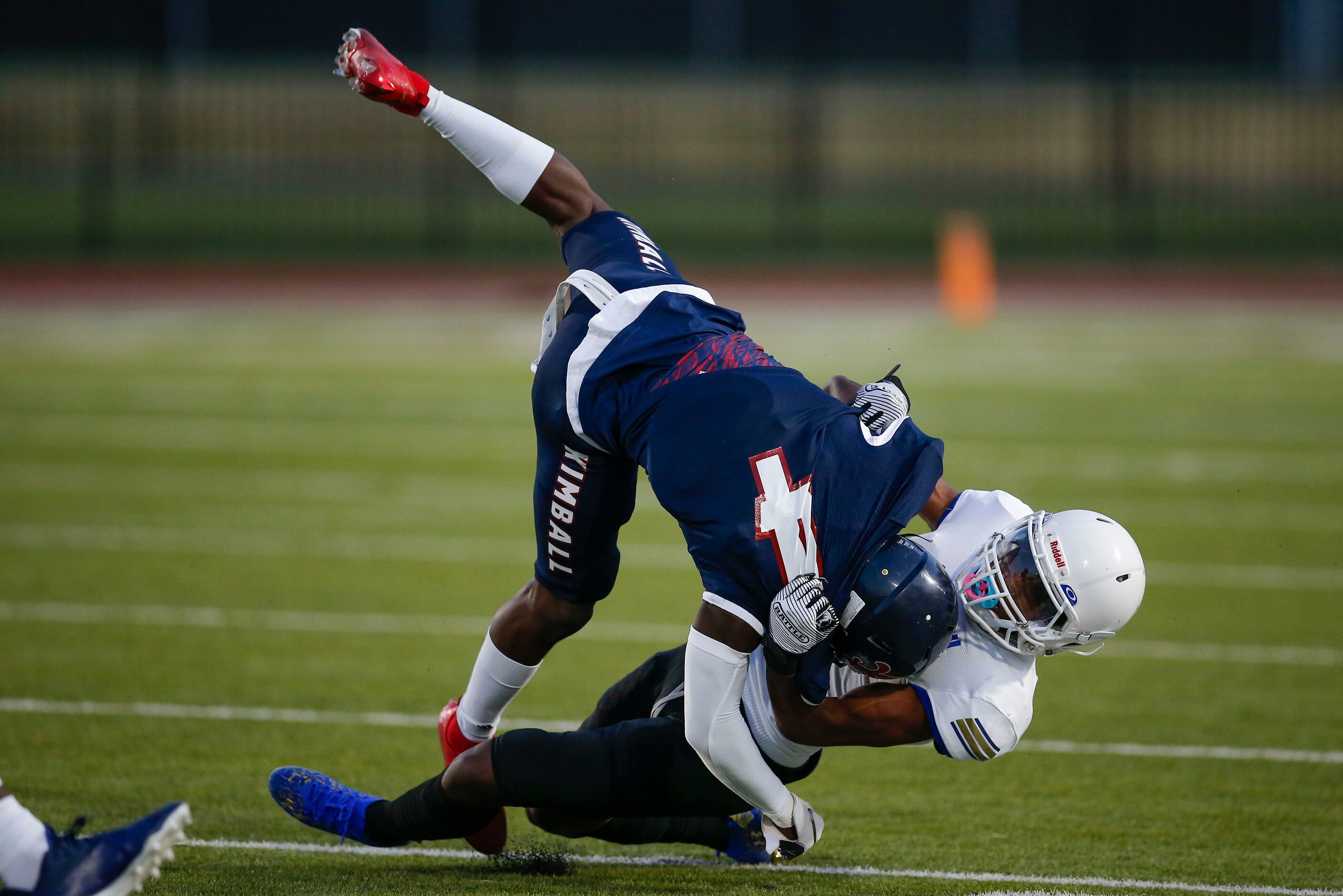 Conrad senior Tony King, right, tackles Kimball senior running back Niteroi Davis (4) during...