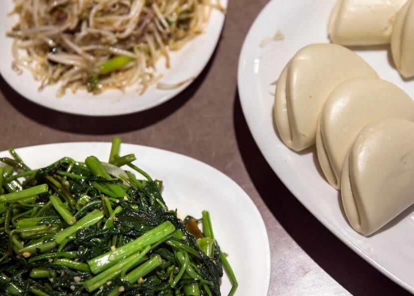 Water spinach, a seasonal green sautéed with garlic, is a good addition to the feast.