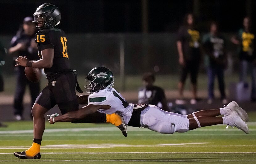 DeSoto quarterback Darius Bailey (15) gets past Waxahachie defensive lineman Jermy Jackson...