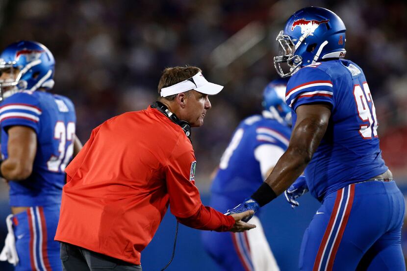 SMU head coach Chad Morris congratulates defensive end Zelt Minor (92) after stopping TCU in...