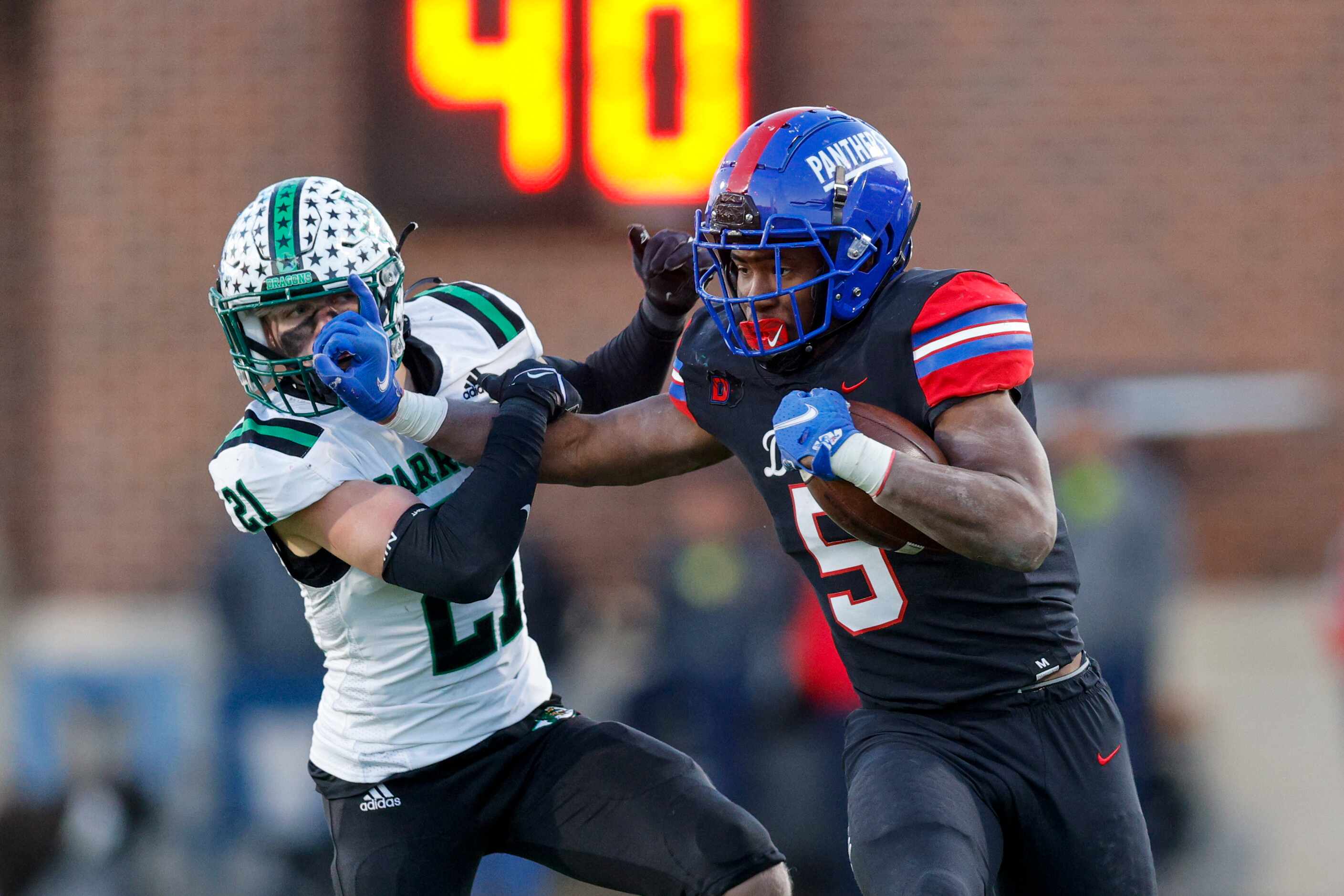 Duncanville running back Malachi Medlock (5) delivers a stiff-arm to Southlake Carroll...