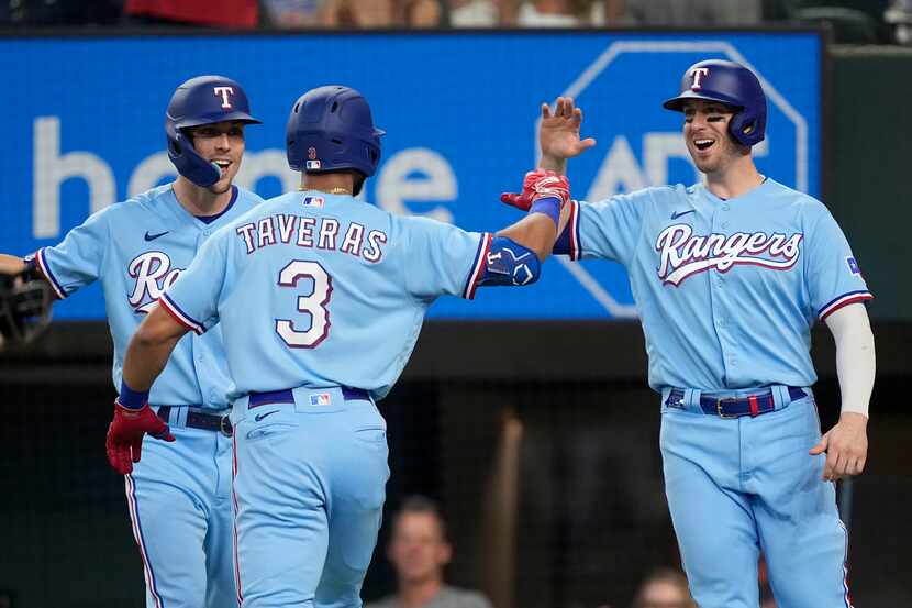 Leody Taveras (3), Evan Carter y Mitch Garver, derecha, de los Rangers de Texas, celebran en...