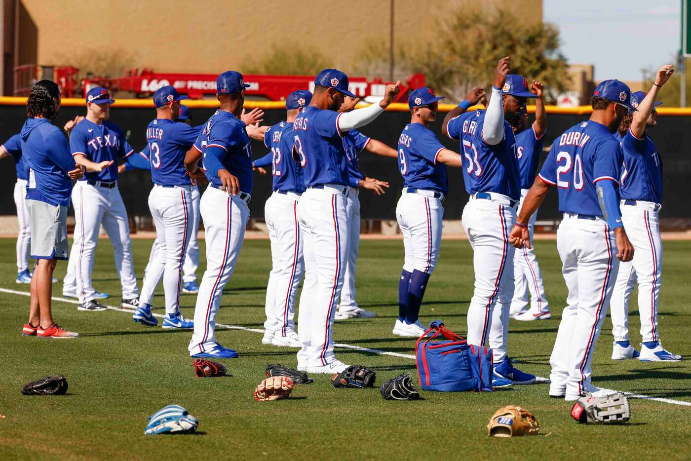 Texas Rangers players warm up ahead of a batting practice during a spring training workout...