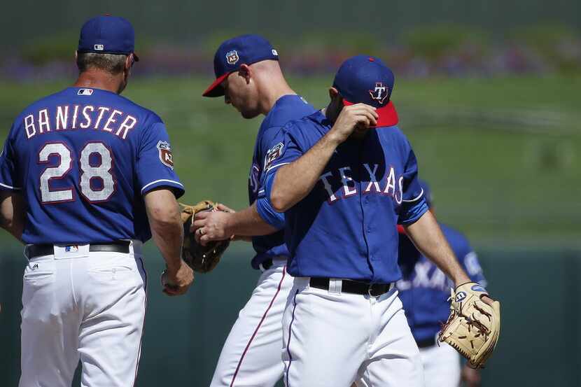 Rangers manager Jeff Banister pulls pitcher Nick Martinez (right) from the game as Chris...