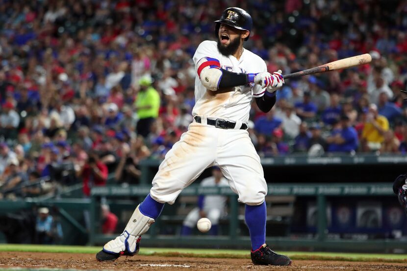 Rougned Odor #12 of the Texas Rangers reacts after being hit by a pitch in the bottom of the...