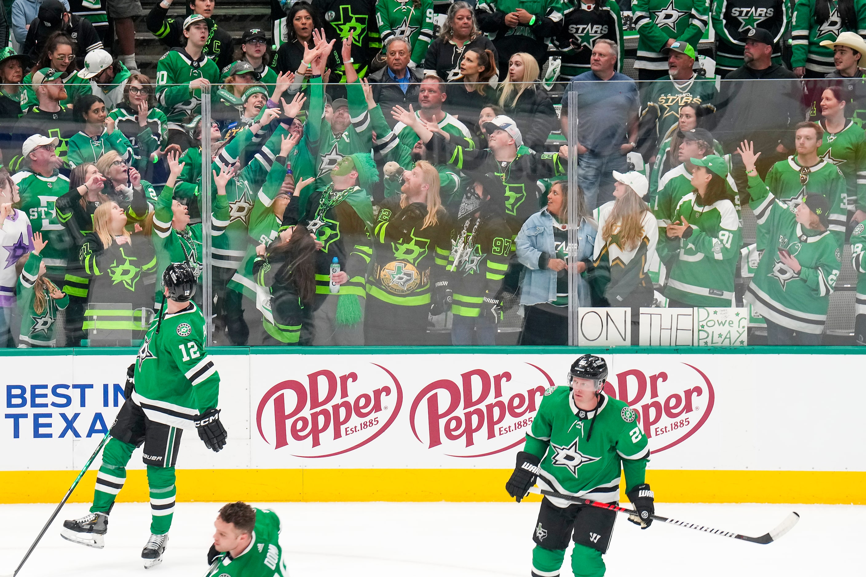 Fans reach for a puck tossed into the stands by Dallas Stars center Radek Faksa (12) as the...