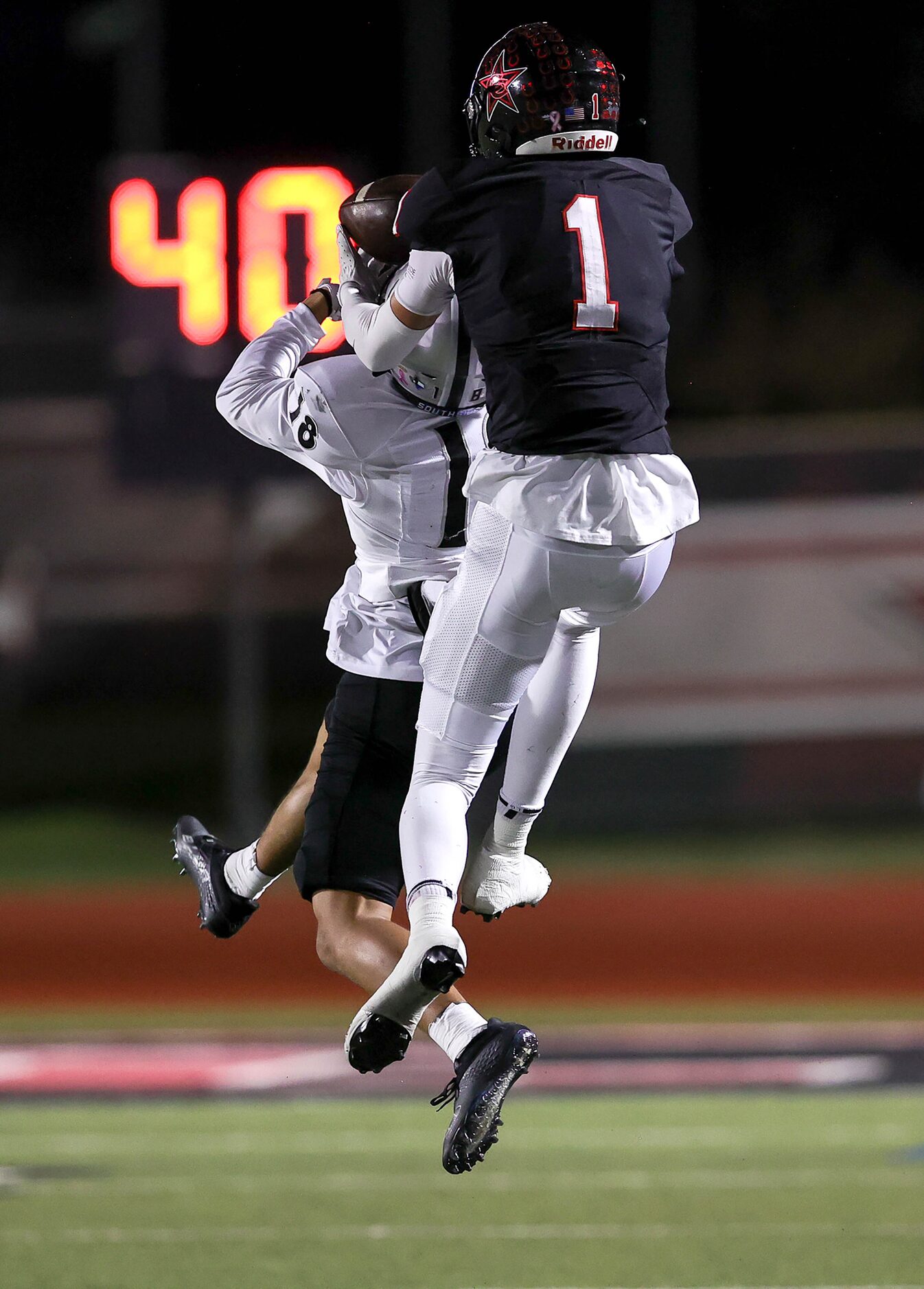 Coppell wide receiver Baron Tipton (1) goes up high to pull in a reception against Denton...