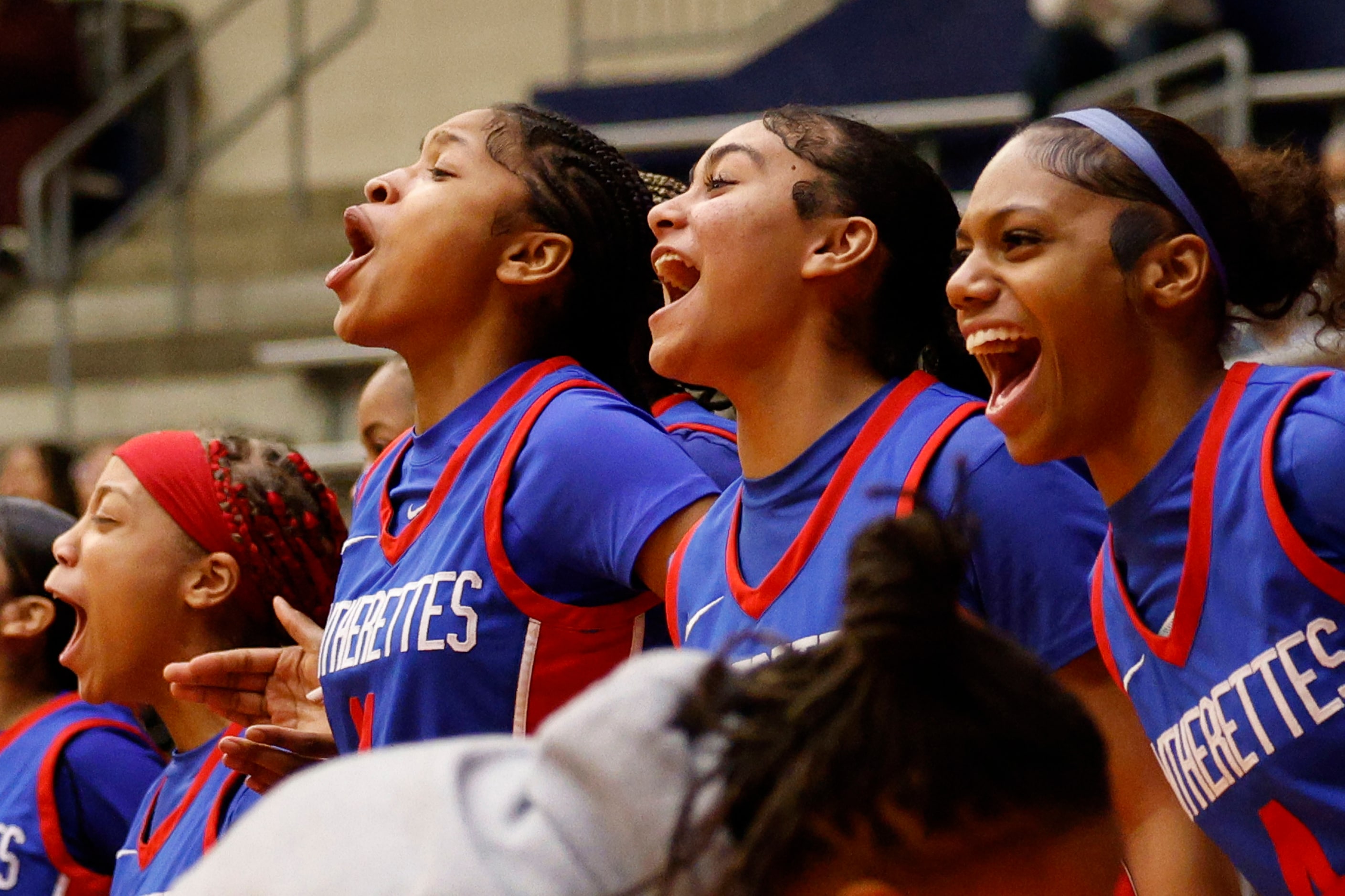 Duncanville players cheer from the bench during the second half of a high school basketball...