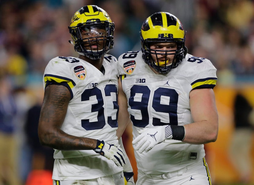 Michigan defensive end Taco Charlton (33) and Michigan defensive tackle Matthew Godin (99)...