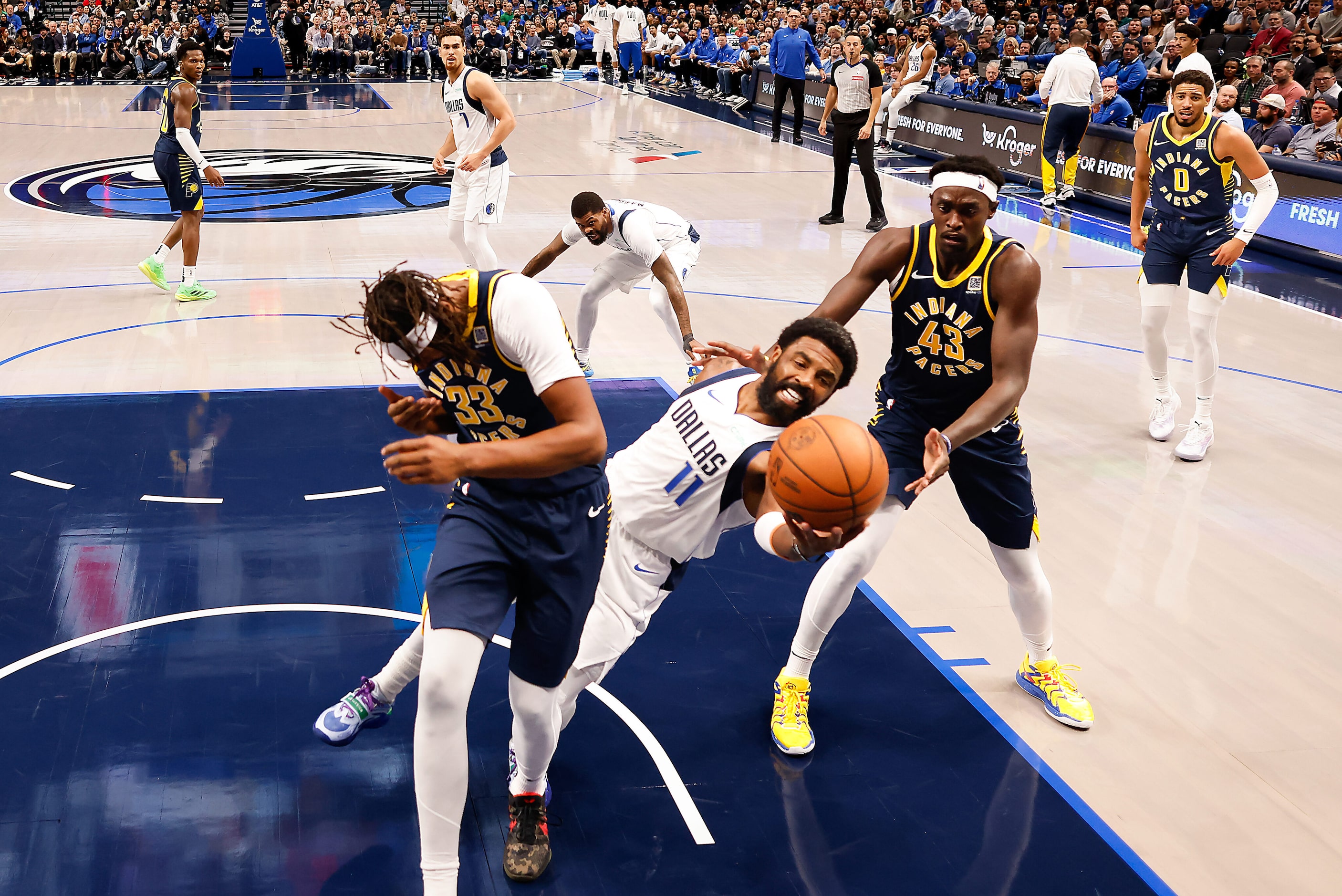 Dallas Mavericks guard Kyrie Irving (11) fights for a rebound between Indiana Pacers center...