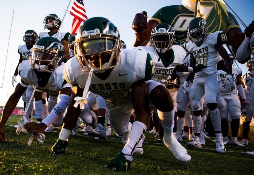 Desoto football players lunge toward the field from the tunnel before a District 7 6A high...