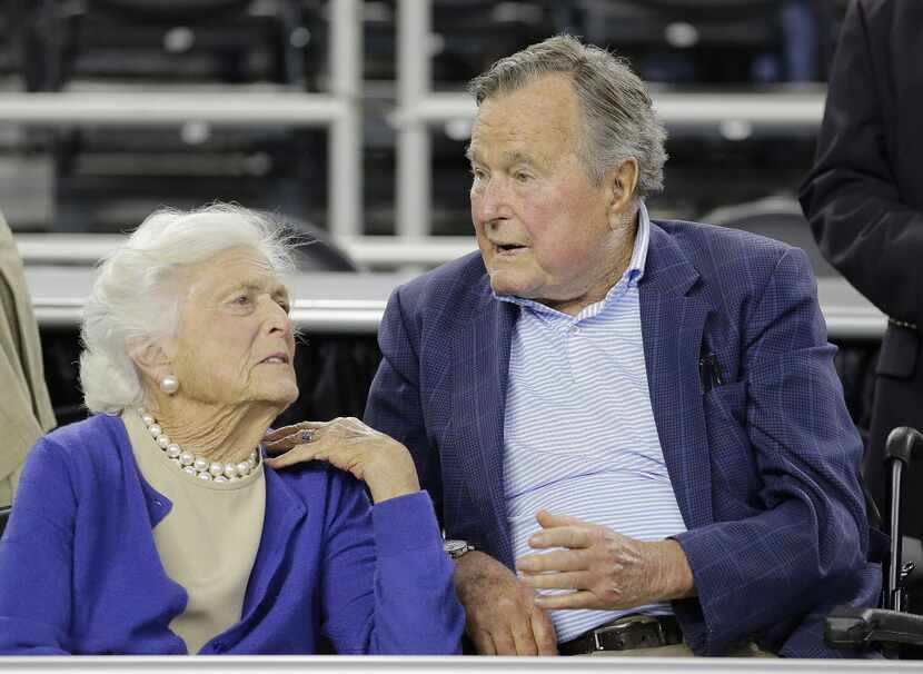 Former President George H.W. Bush and his wife Barbara Bush, left, speak before a college...