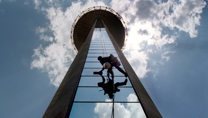 Blake Taylor of Eagle Highrise Inc.  cleans the windows on Reunion Tower's elevator shafts....