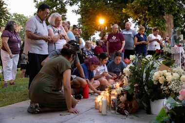 People visit the memorial for the 19 children and two adults killed in the Robb Elementary...