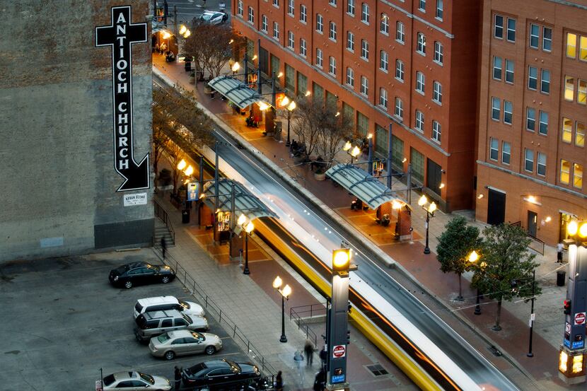 A view of West End station as a long exposure show a DART Rail train crossing Lamar Street...