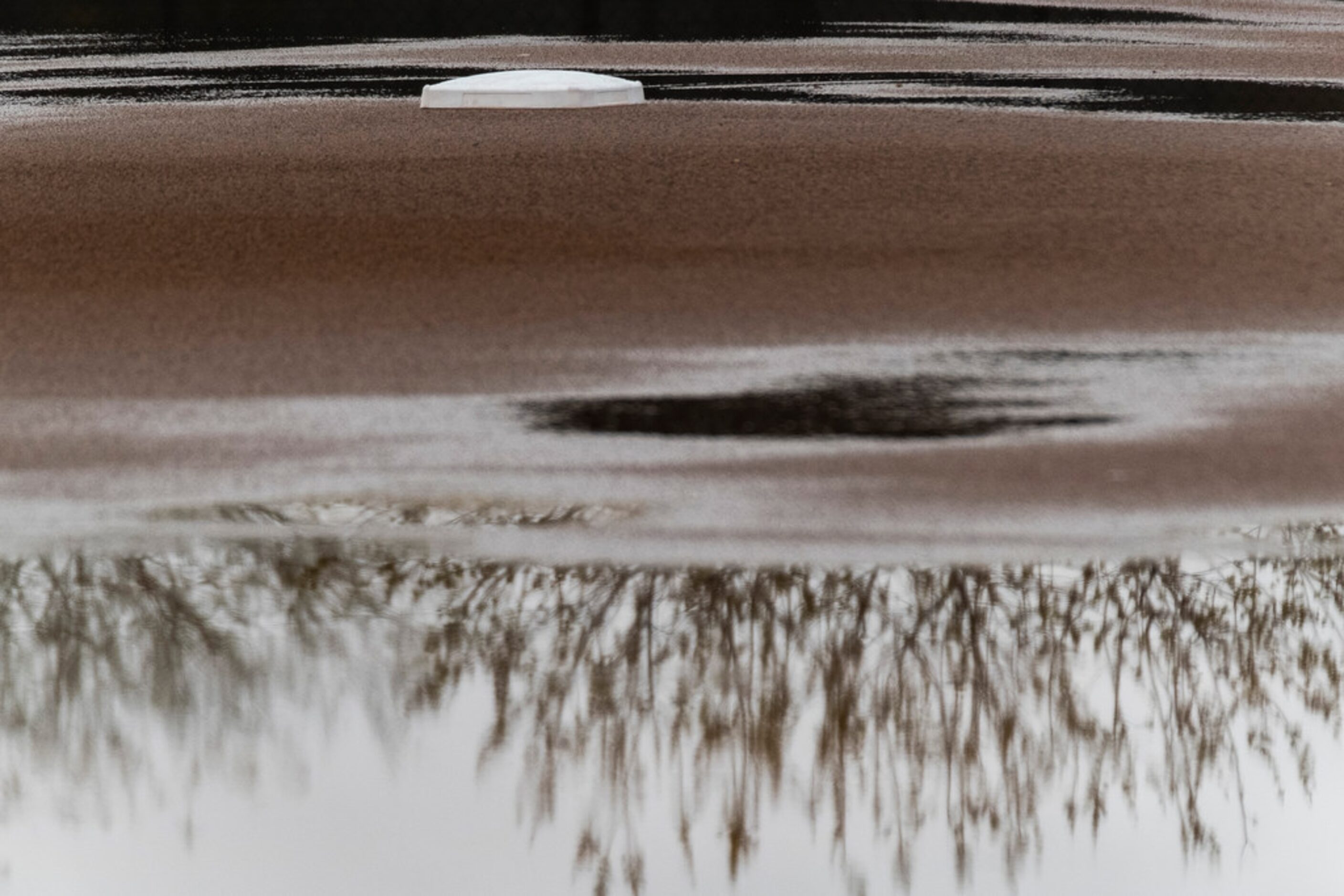 Standing water surrounds second base on a practice field during a Texas Rangers spring...