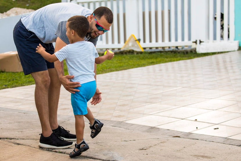 Son Lexiel runs to greet Rangers pitcher Alex Claudio as he arrives at his home after a...