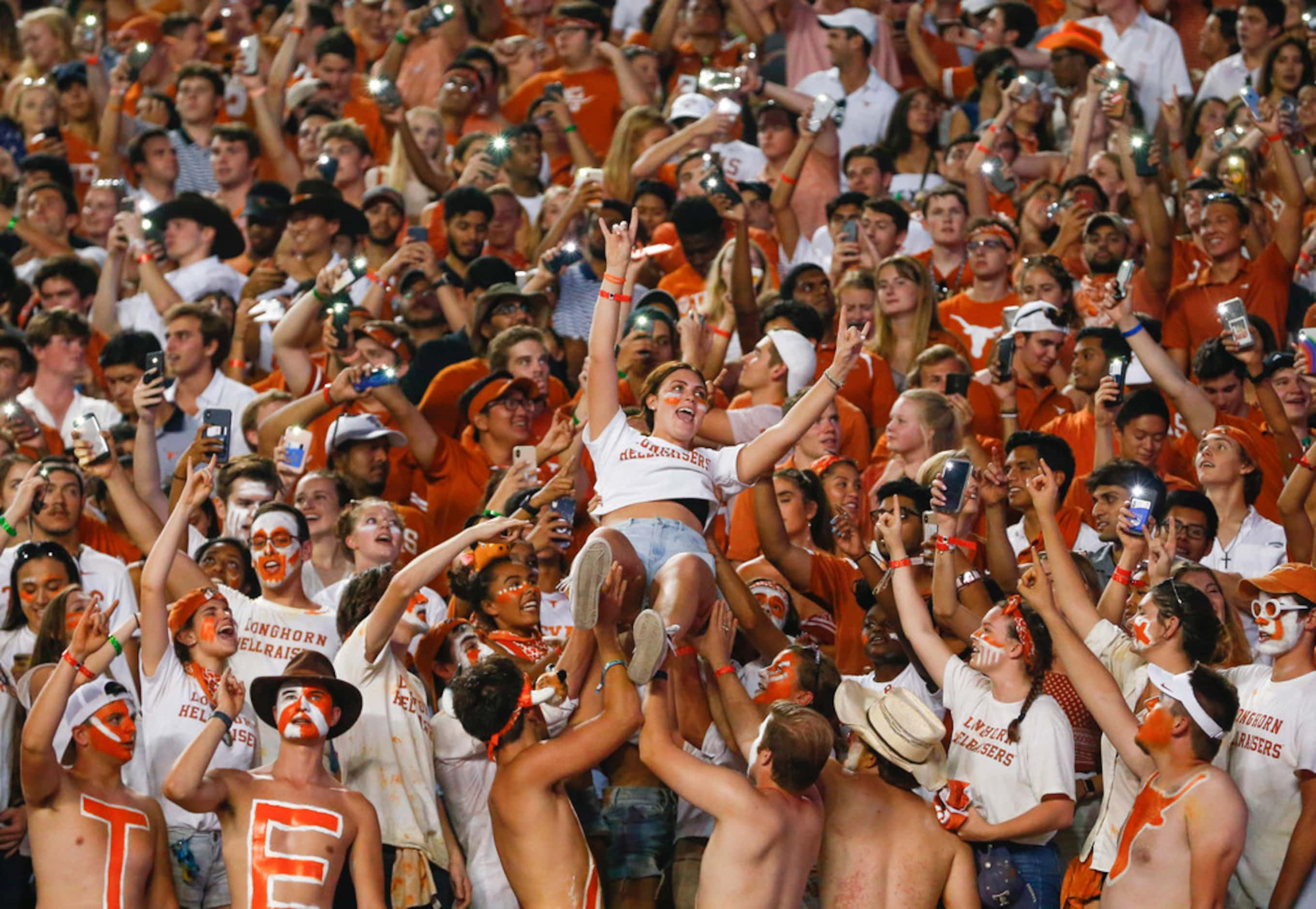 A student fan is lifted into the air during the third quarter of a college football game...