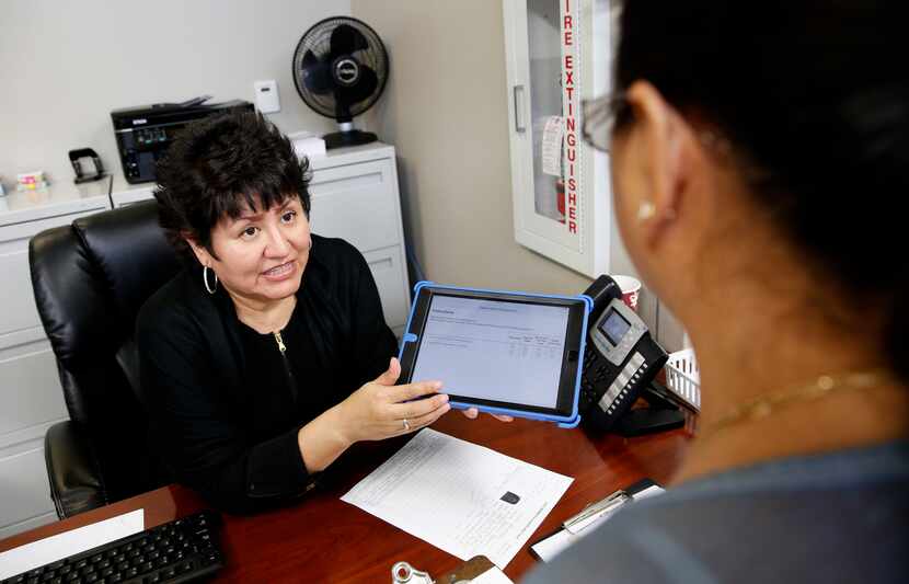 Leticia Balderas, clinic receptionist, explains how to fill out the VitalSign6 survey to...