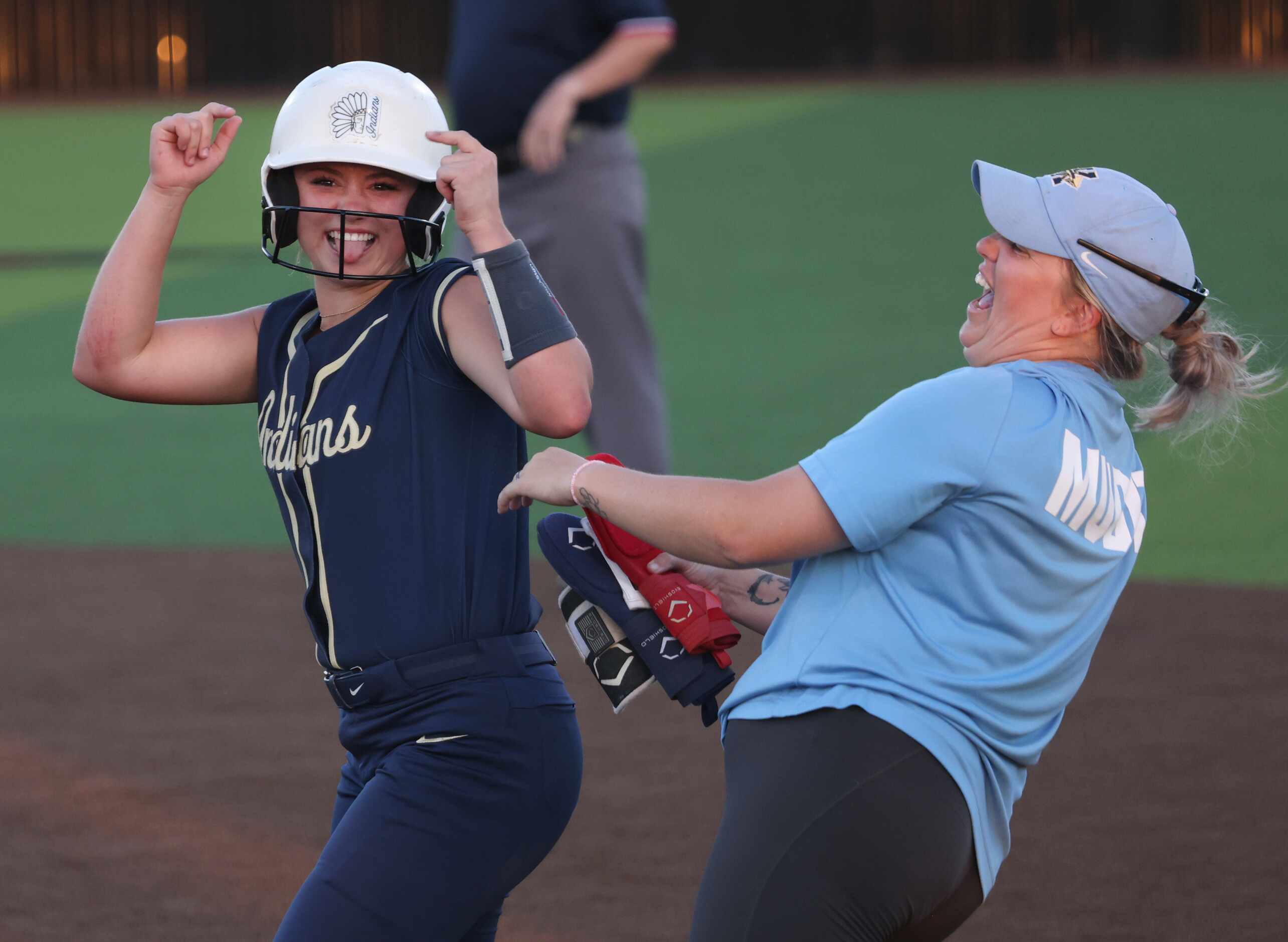 Keller's Mackenna Jackson (8), left, celebrates with an assistant coach at first base after...