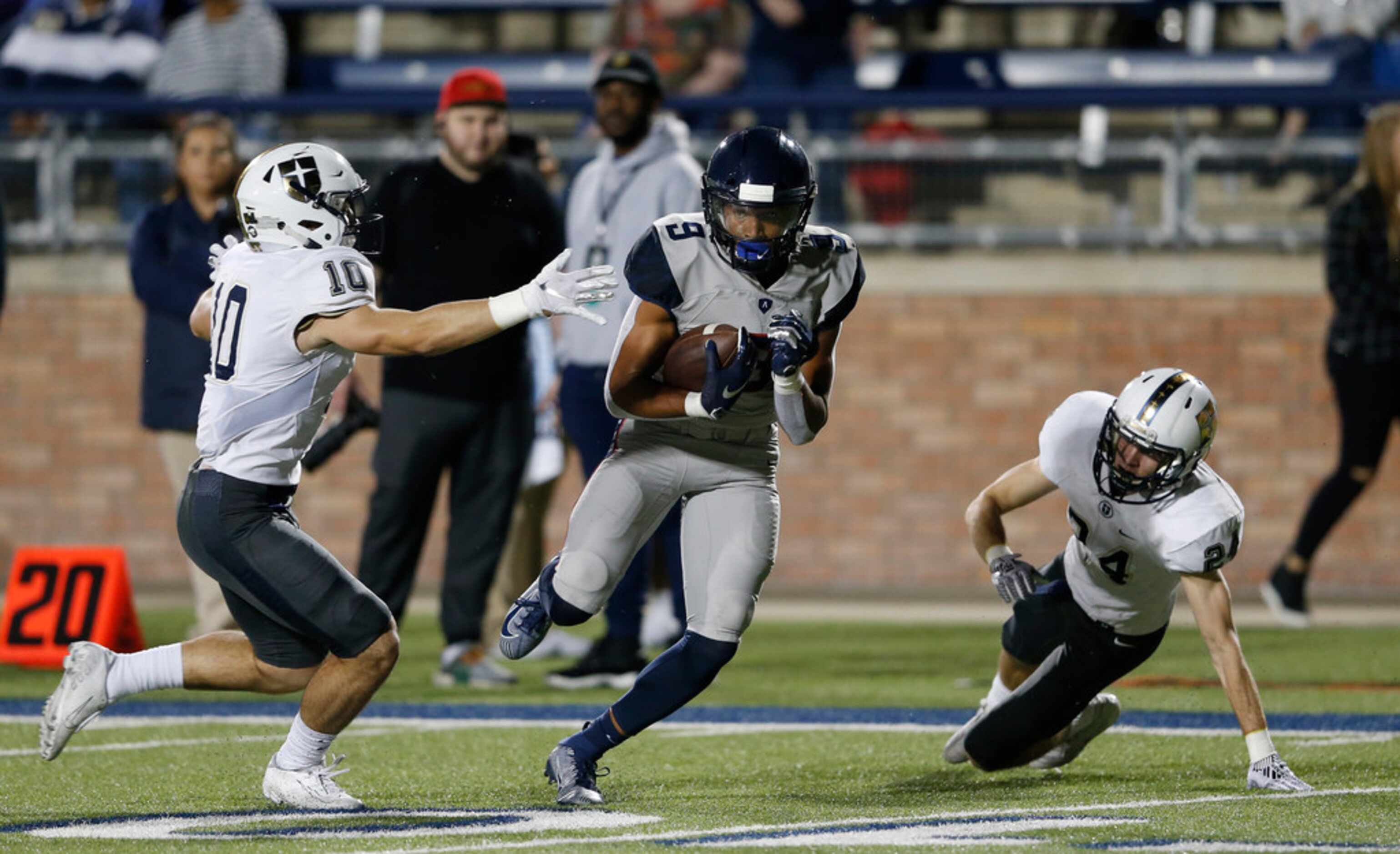 Allen's Bryson Green (9) splits Jesuit's Mitchell Campbell (10) and Zach Pendola (24) on his...