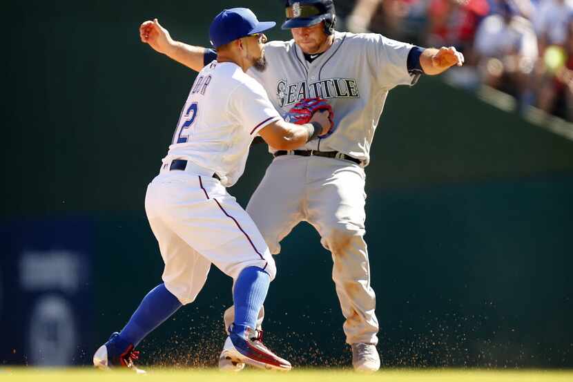 Seattle Mariners runner Chris Iannetta (33) is tagged out by Texas Rangers second baseman...