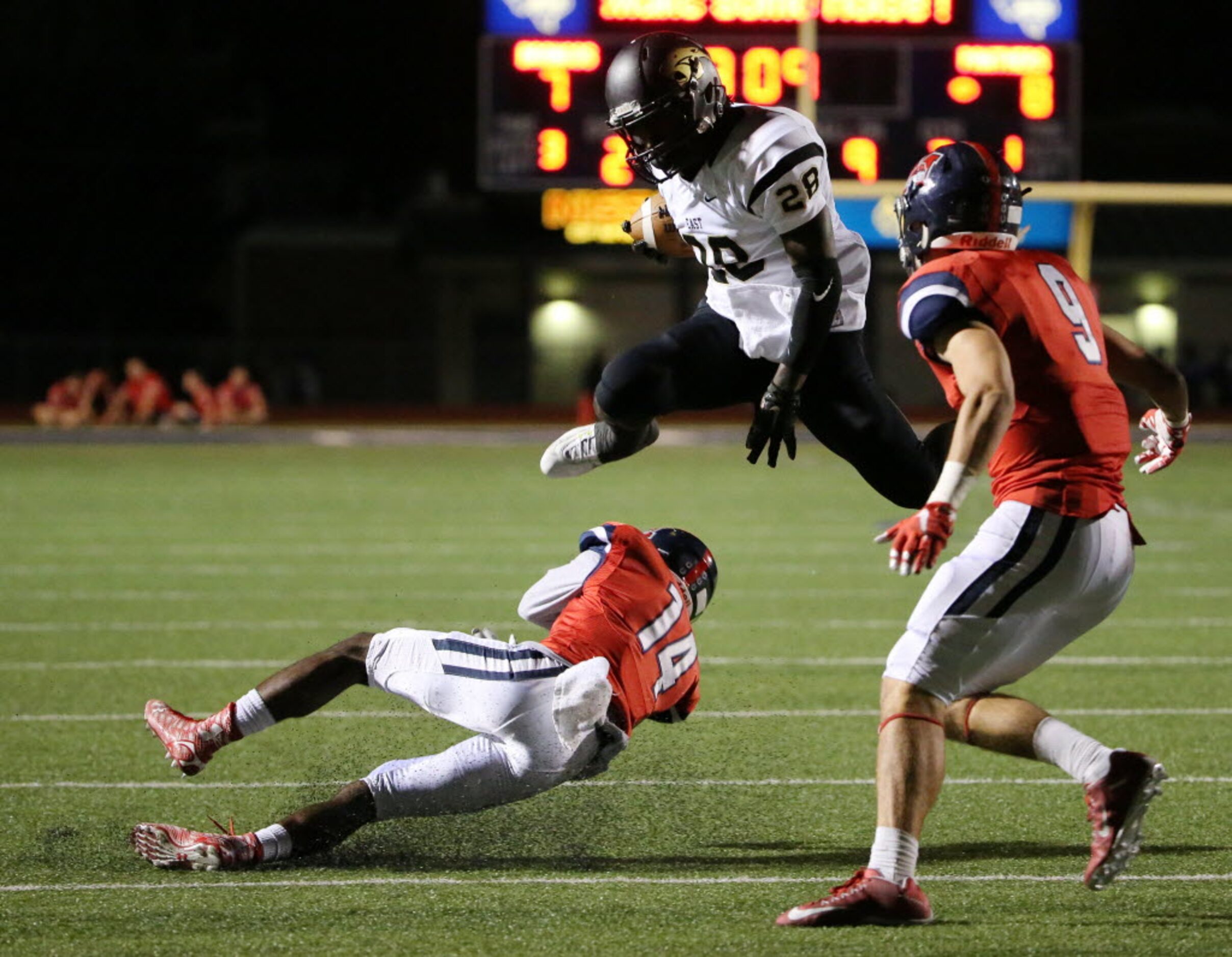 Plano East running back Desmond Bowden (28) leaps over McKinney Boyd defensive back Armani...