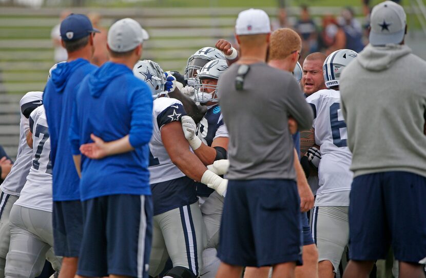 Cowboys players separate tackle La'el Collins (71) and defensive end Taco Charlton (97)...