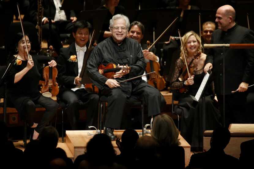 Violin soloist Itzhak Perlman receives a standing ovation from the audience before playing...