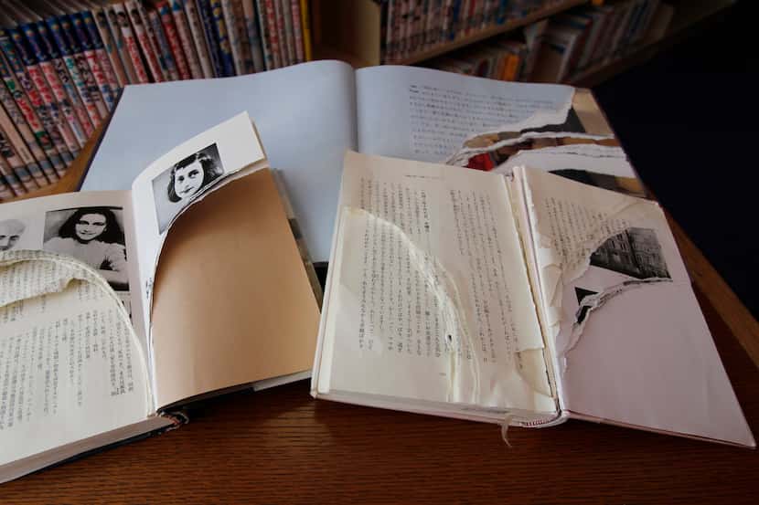 Ripped copies of Anne Frank's "Diary of a Young Girl" and related books are shown at...