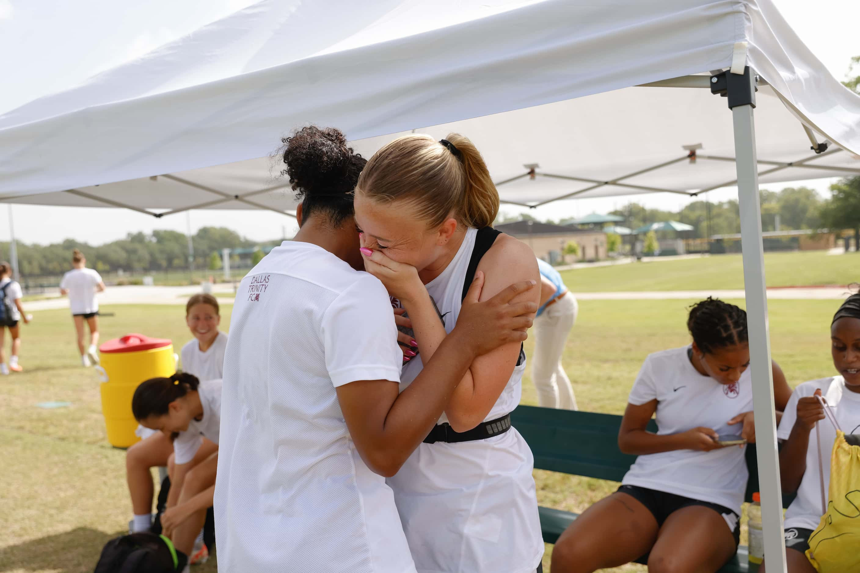 Dallas Trinity FC player Haley Berg, right, laughs with a fellow teammate following the...