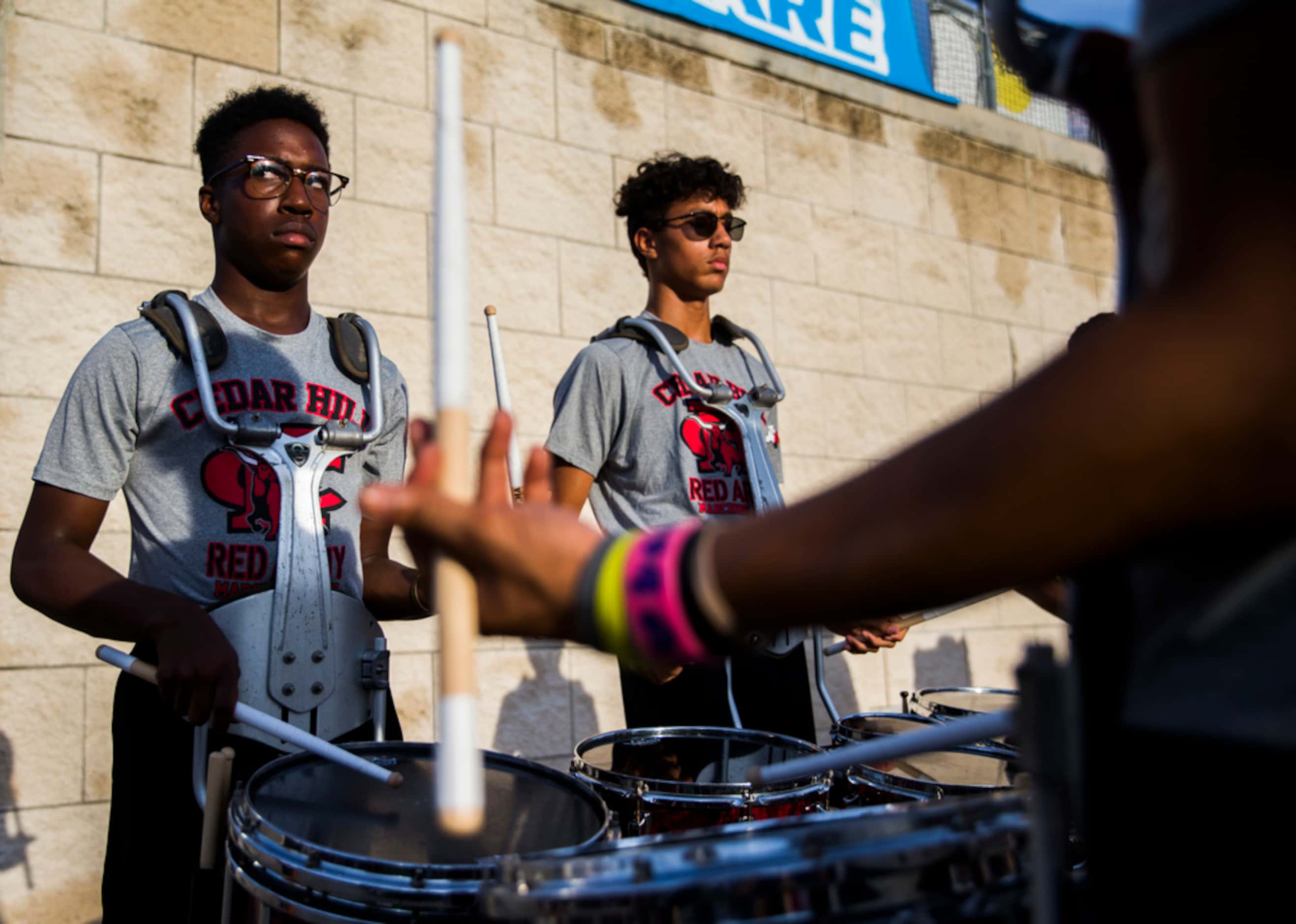 Cedar Hill snare drummers play on the sideline before a high school football game between...