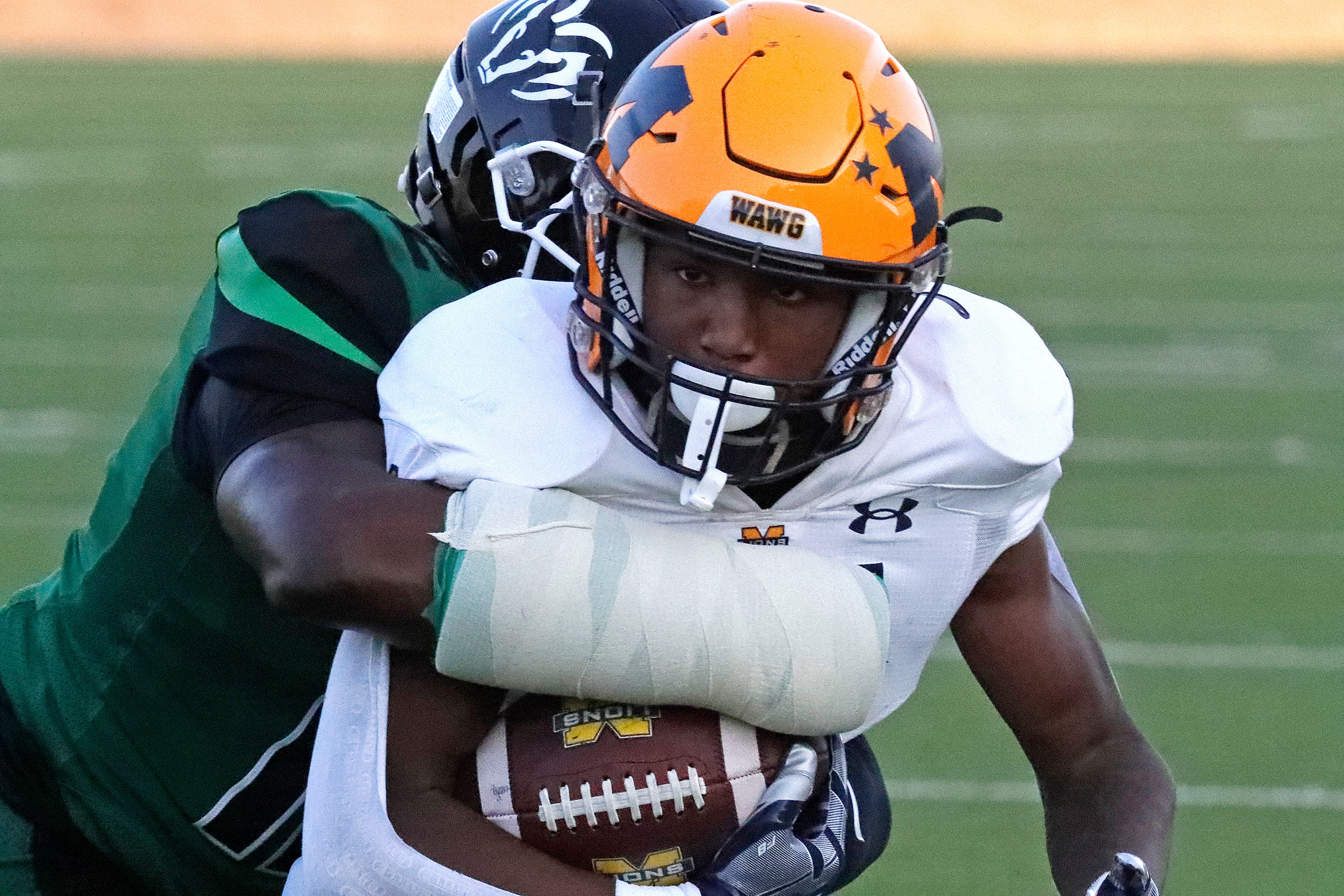 McKinney High School running back Ja'Tavious Greer (21) is tackled by Berkner High School...