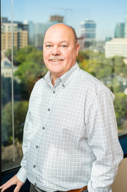 Man standing by window with skyline view behind him