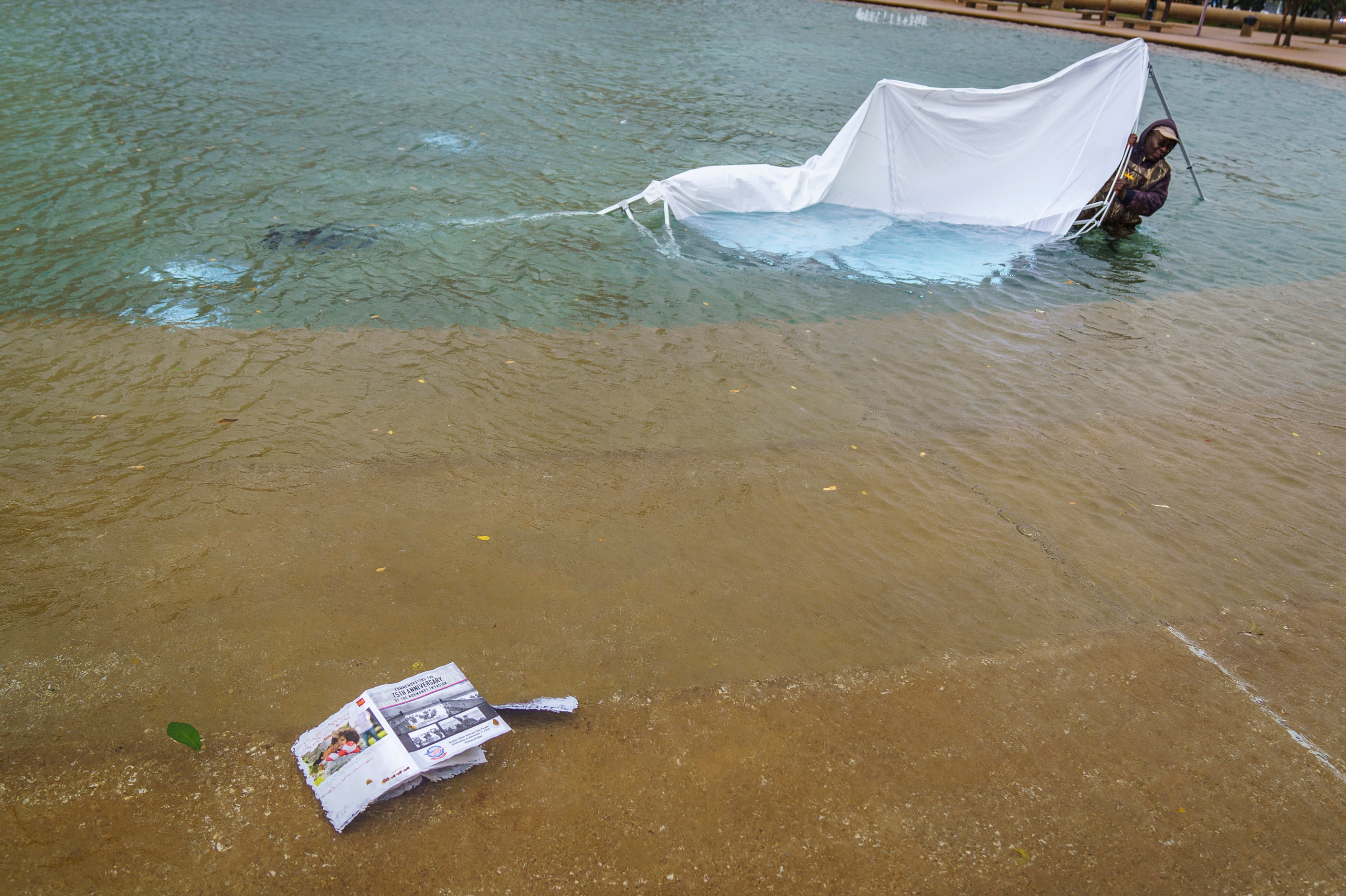 A city employee retrieves a Dallas Parks and Recreation Department tent that was blown into...