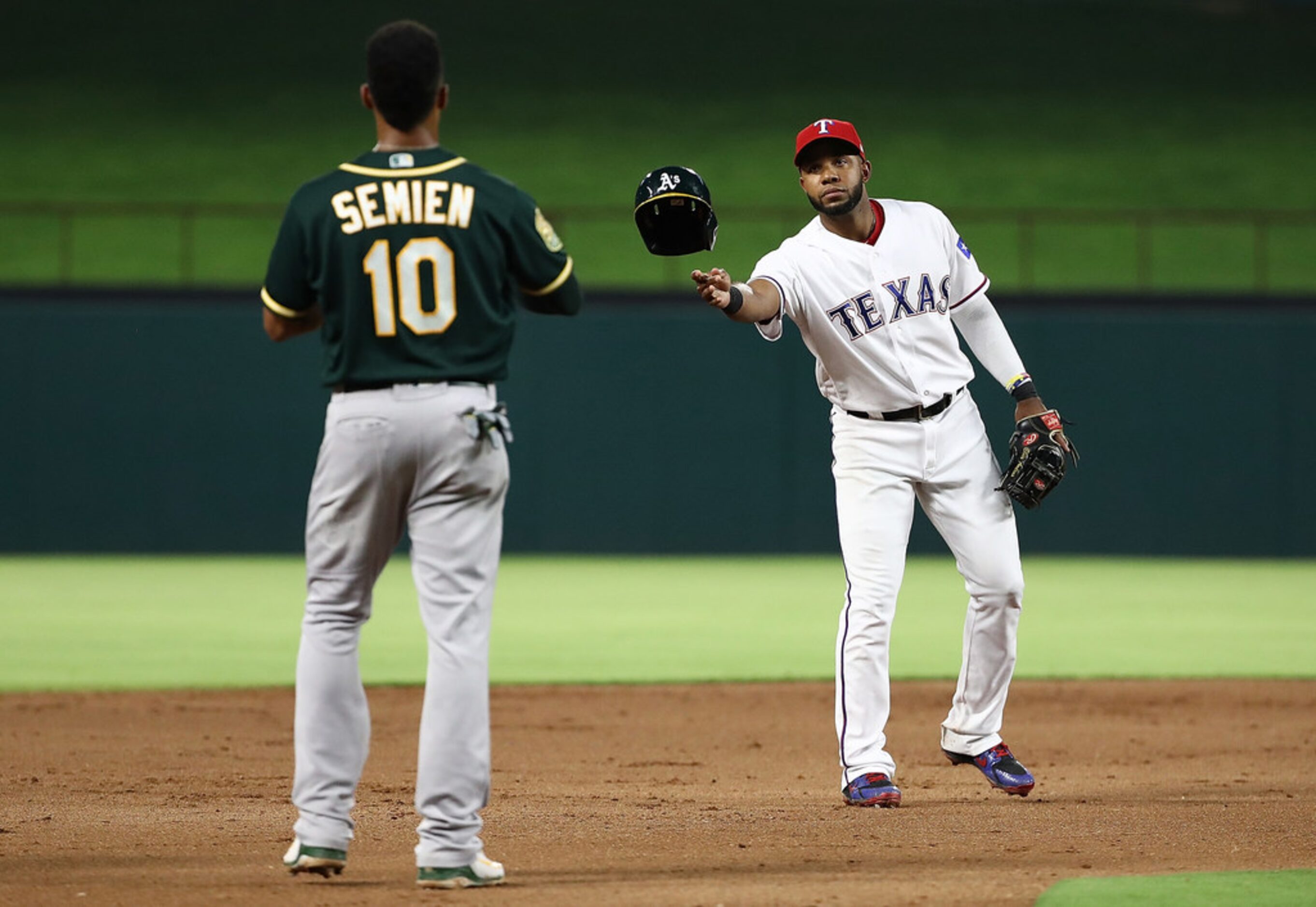 ARLINGTON, TX - JULY 25:  Elvis Andrus #1 of the Texas Rangers throws the batting helmet to...