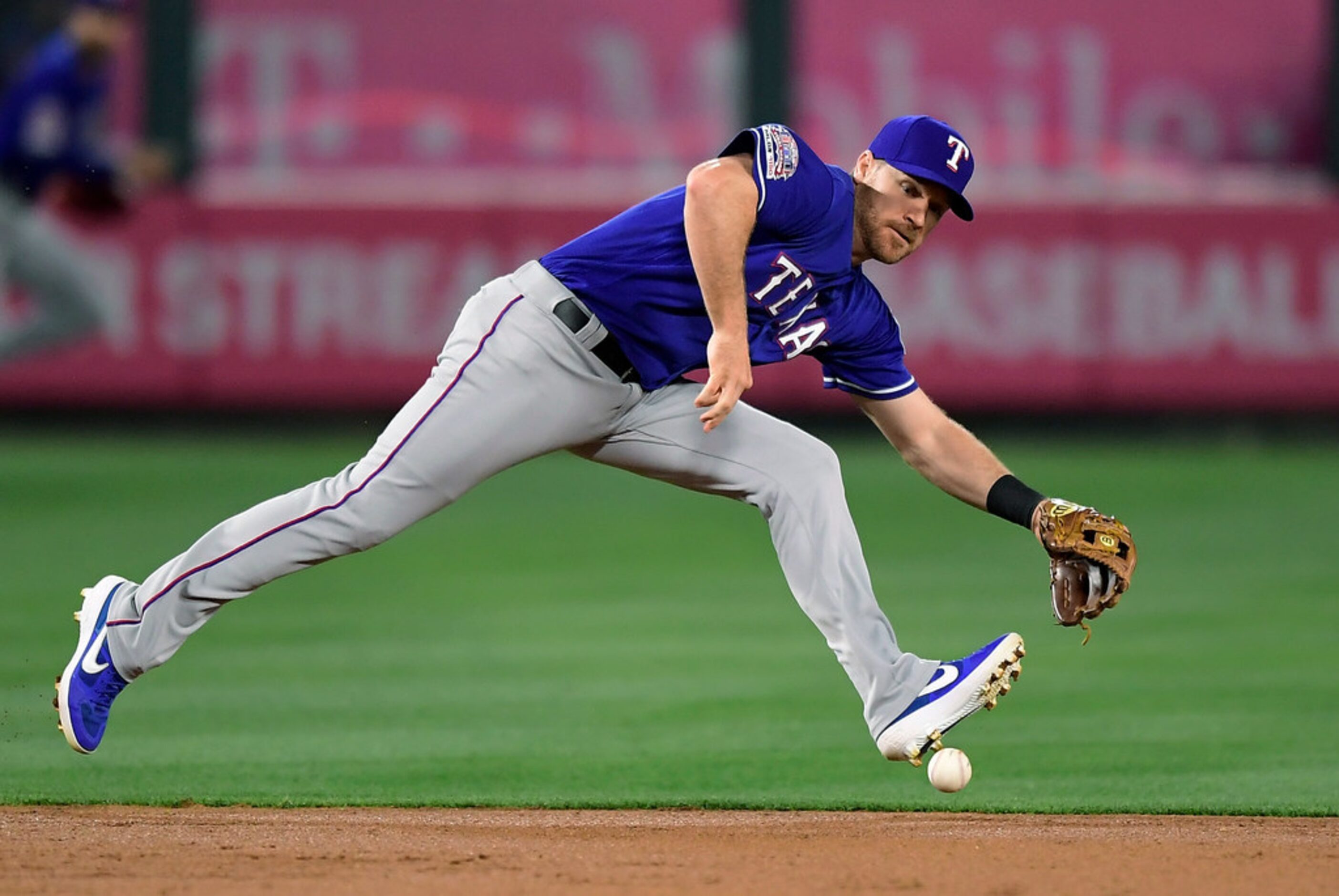 Texas Rangers second baseman Logan Forsythe can't handle a ball hit for a single by Los...