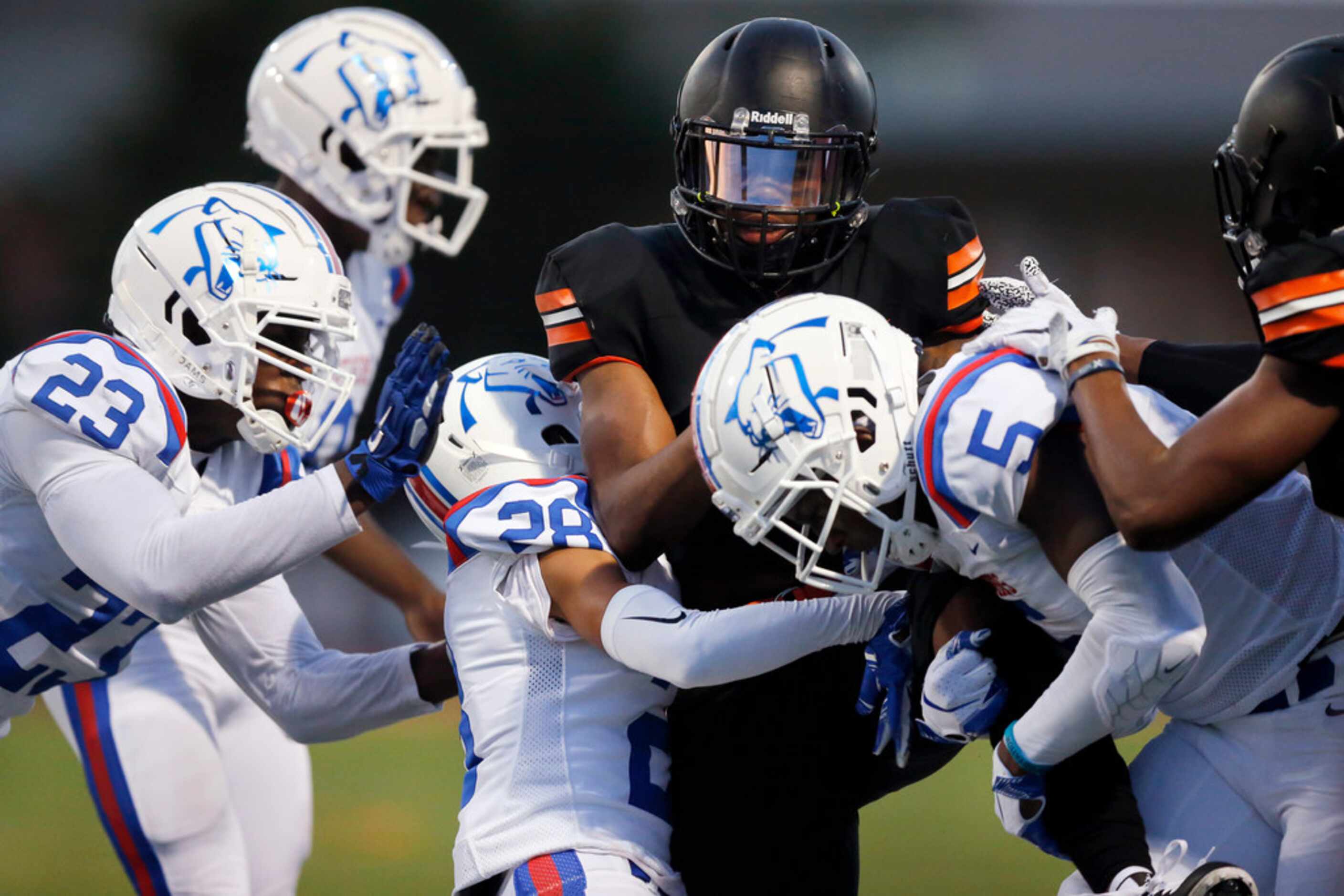 Lancaster running back Tre Bradford (2) is wrapped up by Duncanville defenders Omari Abor...