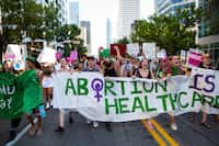 Abortion-rights protesters march down Congress Avenue in downtown Austin, Texas following...