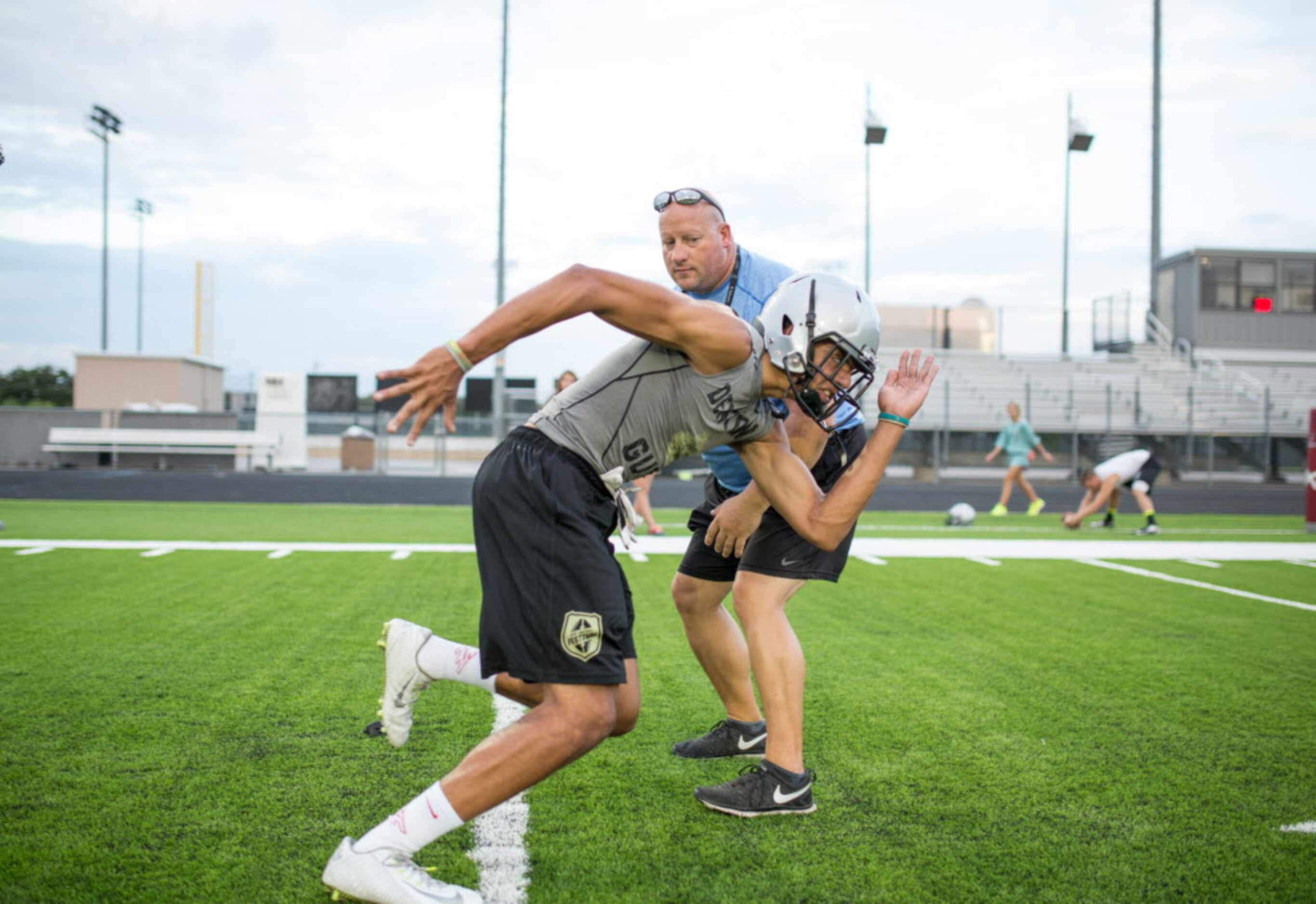 Alex Honey works with Coach Russ Philips during the first day of two-a-days at Denton Guyer...