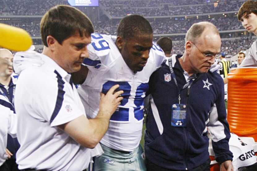 DeMarco Murray (29) is assisted to the locker room by trainers after getting injured in the...