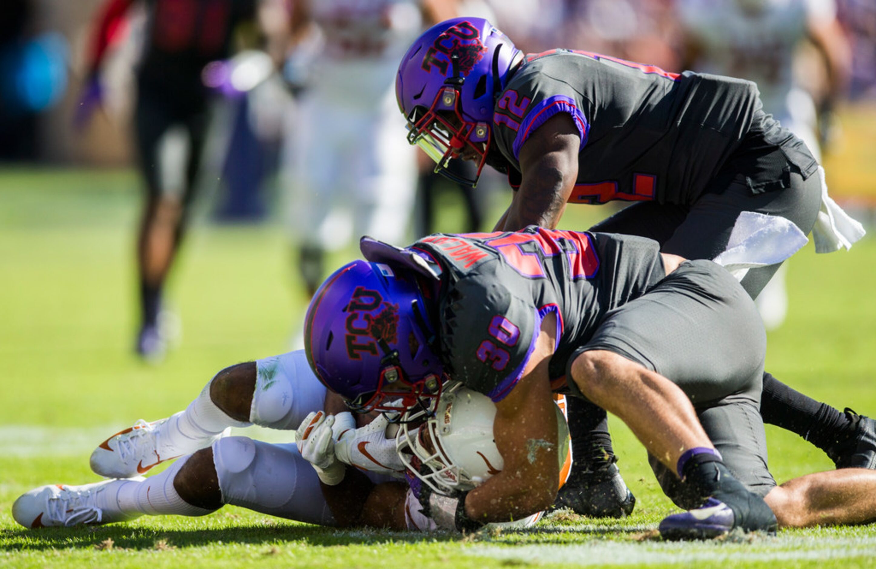 TCU Horned Frogs linebacker Garret Wallow (30) and cornerback Jeff Gladney (12) tackle Texas...