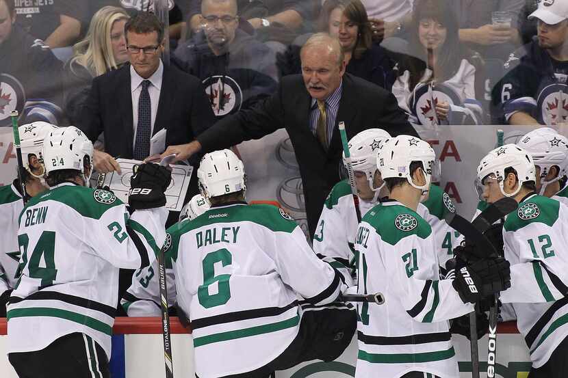 Lindy Ruff of the Dallas Stars talks to his players from the bench in third-period action of...
