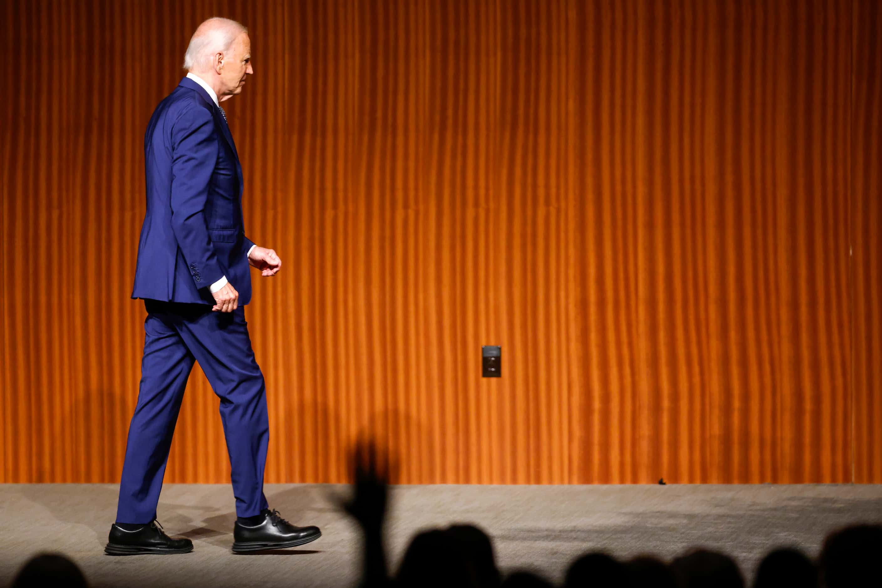 President Joe Biden walks off the stage to a standing ovation after giving the keynote...
