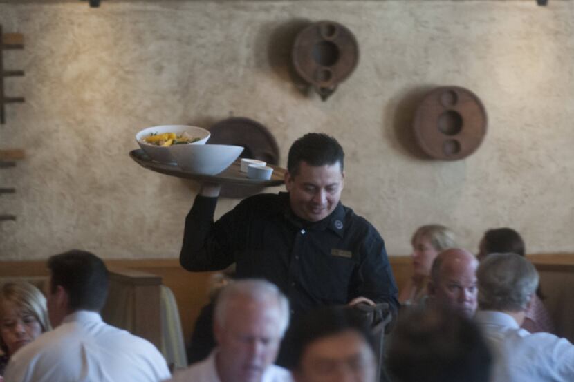 Antonio Soriano delivers food to a table at Cantina Laredo. The restaurant’s parent company...