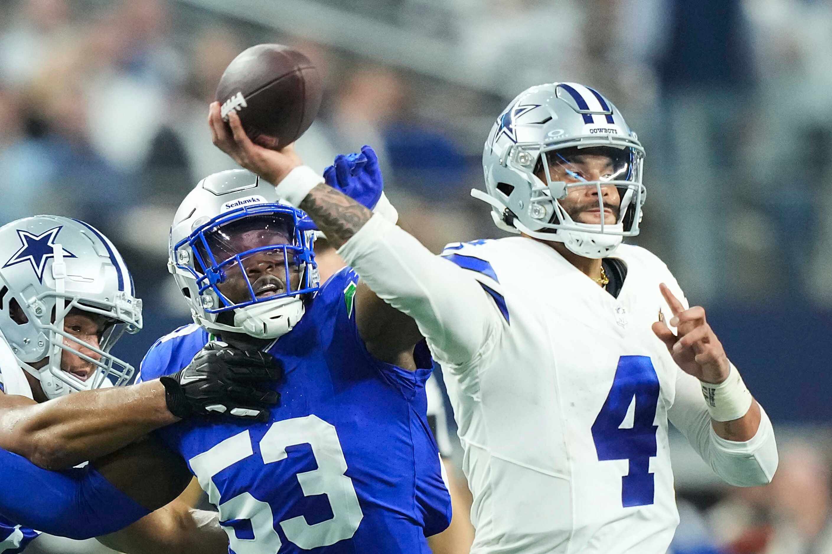 Dallas Cowboys quarterback Dak Prescott (4) throws a pass under pressure from Seattle...