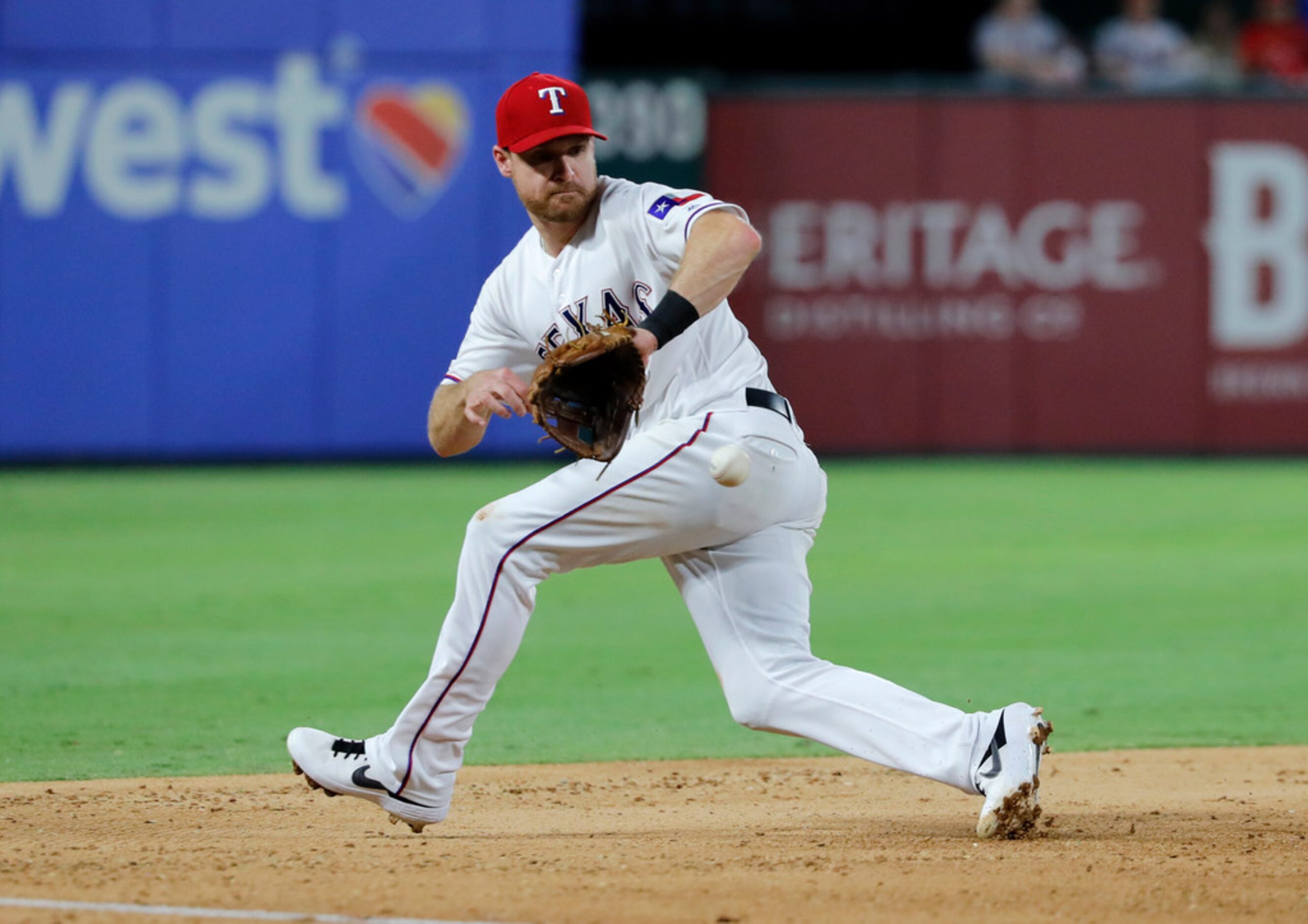 Texas Rangers third baseman Logan Forsythe fields a ground out by Los Angeles Angels' Max...