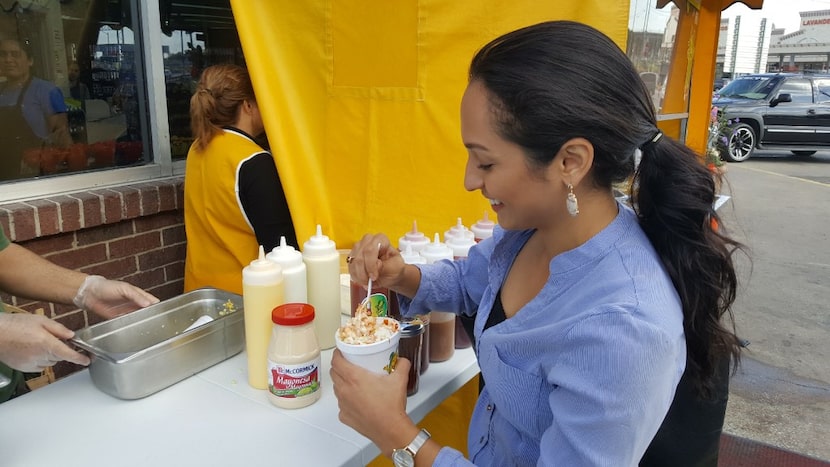 Dallas Morning News reporter Cassandra Jaramillo tries an elote at Elotes Fanny in Dallas.