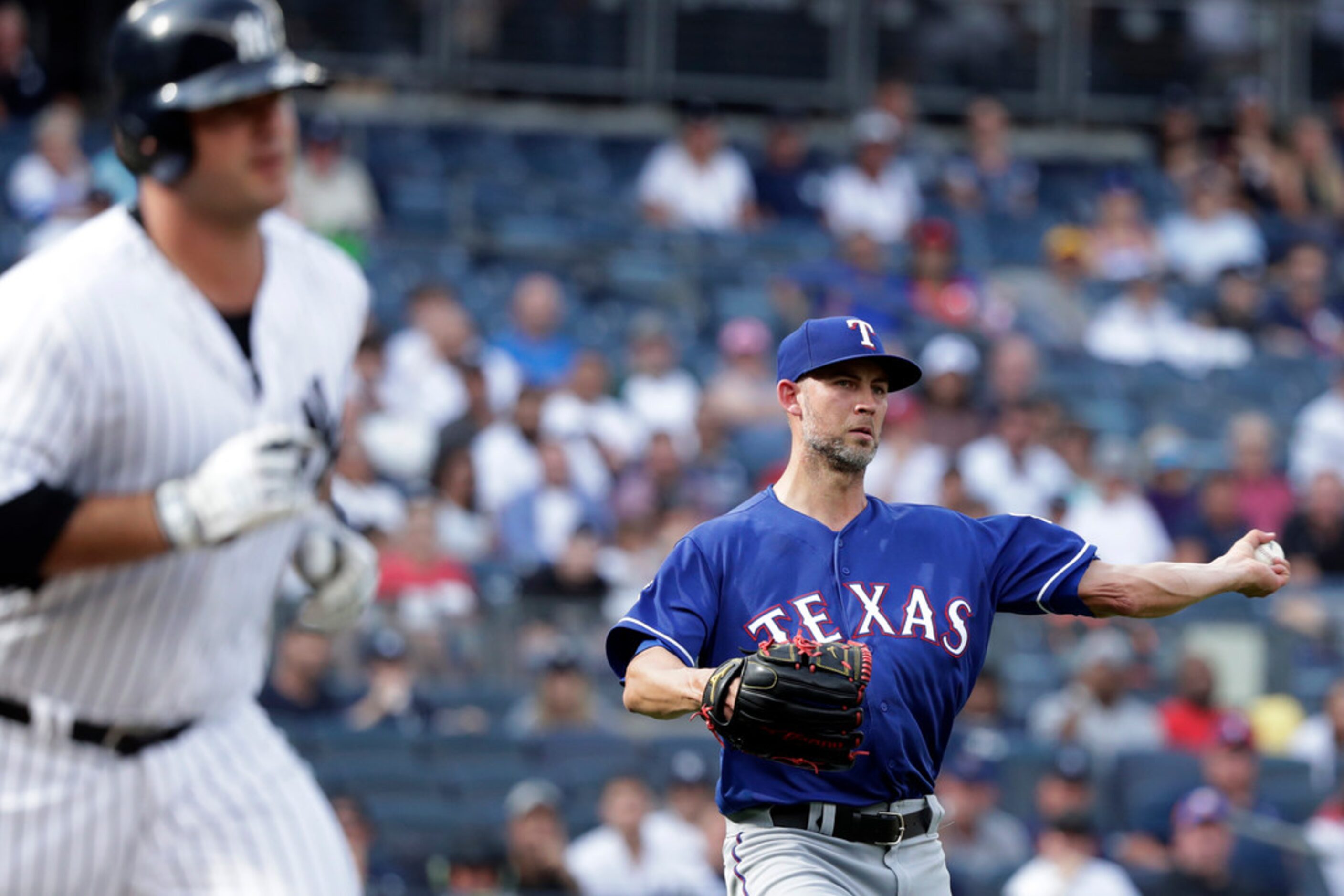 Texas Rangers pitcher Mike Minor, right, throws out New York Yankees designated hitter Mike...